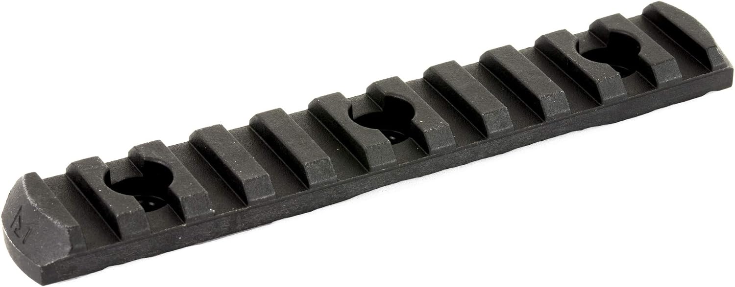 A black textured metal or polymer rail accessory with a series of raised rectangular teeth and circular cutouts, shown on a plain white background.