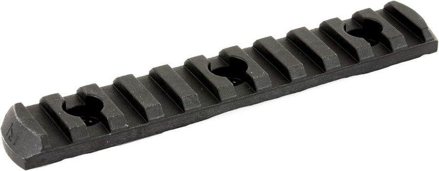 A black textured metal or polymer rail accessory with a series of raised rectangular teeth and circular cutouts, shown on a plain white background.